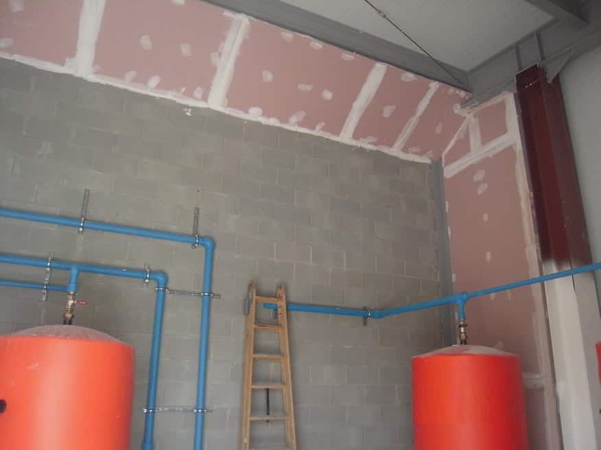 Tabique de placas cortafuegos montado sobre muro de bloque en una sala técnica